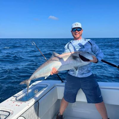 a person holding a fish on a boat in the water